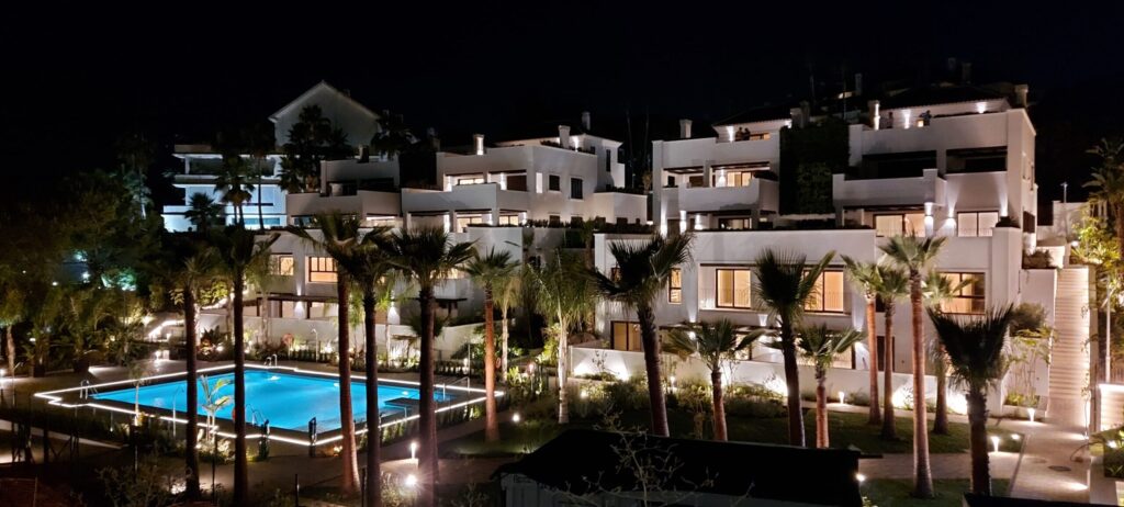 Complejo residencial de lujo con iluminación arquitectónica y piscina iluminada en Marbella
