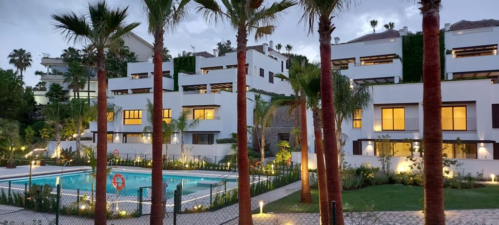 Complejo residencial moderno con jardines iluminados y piscina en Marbella