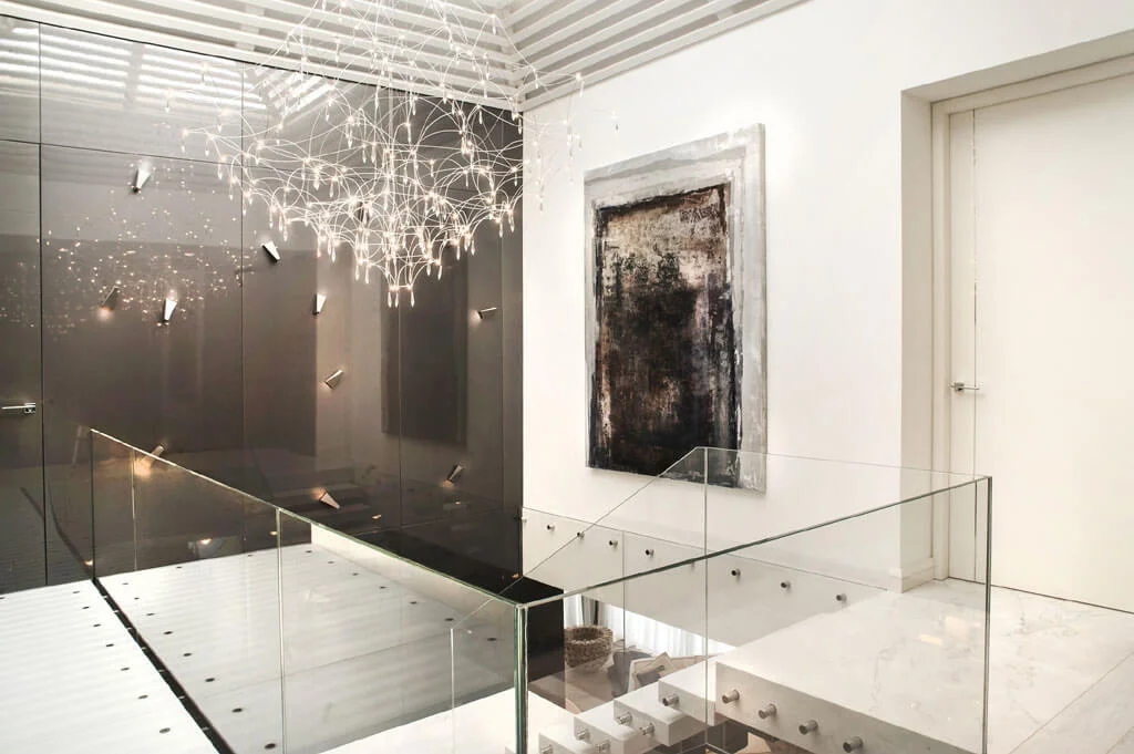 Escalera interior con lámpara de diseño moderno y iluminación decorativa en vivienda de lujo en Marbella